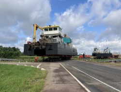 De varende zandzuiger Rotterdam 58 is een honderdtonner. Hier ging die over de weg van de voorhaven naar de binnendijkse zandwinplas in Geertjesgolf bij Deest.